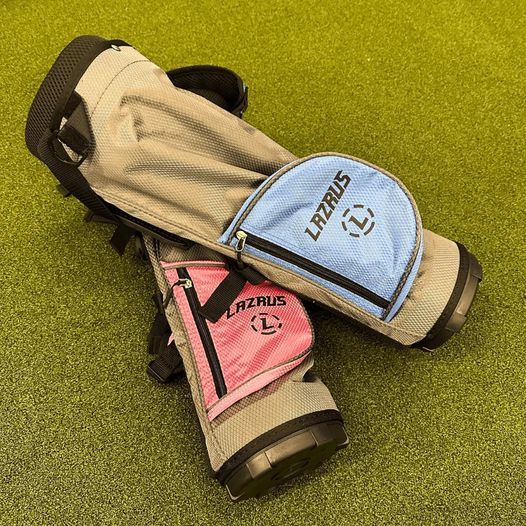 Two Lazrus junior golf bags in beige with blue and pink pockets on green turf
