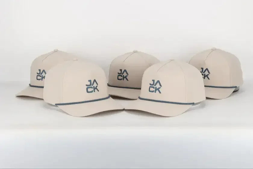 Five beige baseball caps with blue JACK logo and blue trim on the brim, arranged in a row