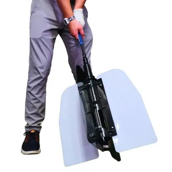 Person demonstrating a golf swing training aid with large white wing panels and black mechanical parts