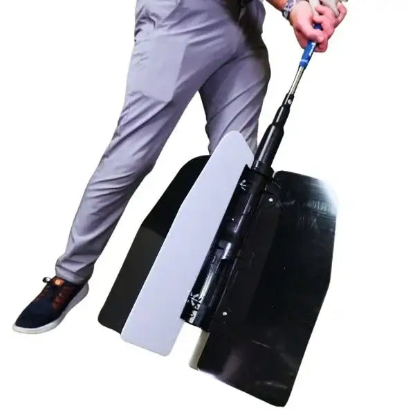 Golfer in gray pants demonstrating golf power swing training device with black and white panels