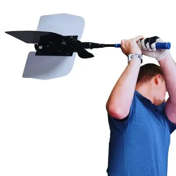 Man in blue shirt practicing golf swing with a training device attached to golf club
