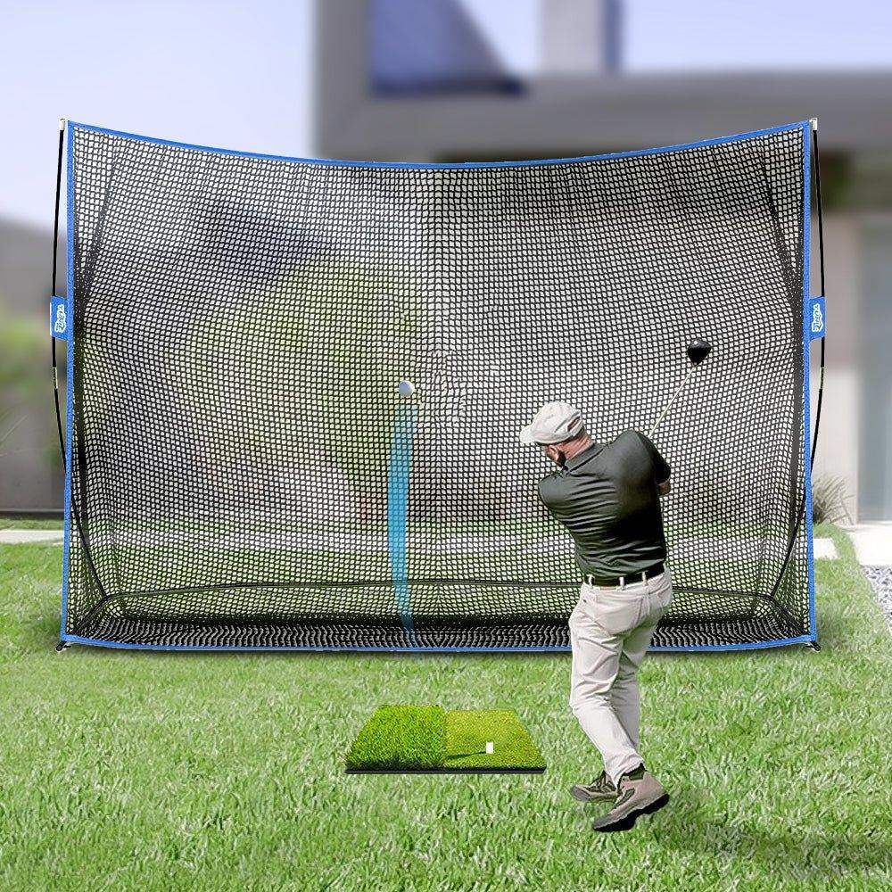 Man practicing golf swing outdoors with large golf practice net and artificial turf mat