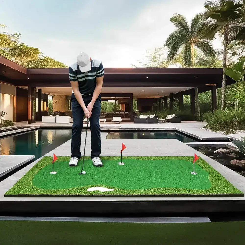 Man putting on a 5ft x 10ft golf putting green mat outdoors near modern home pool