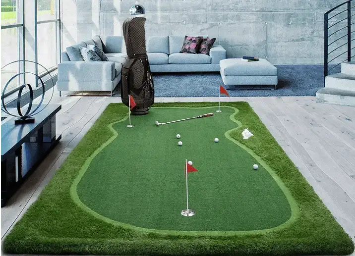 Indoor golf putting green mat with flags, golf balls, putter, and golf bag in modern living room