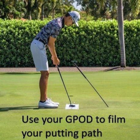Golfer using GPOD device on putting green to film putting stroke and path