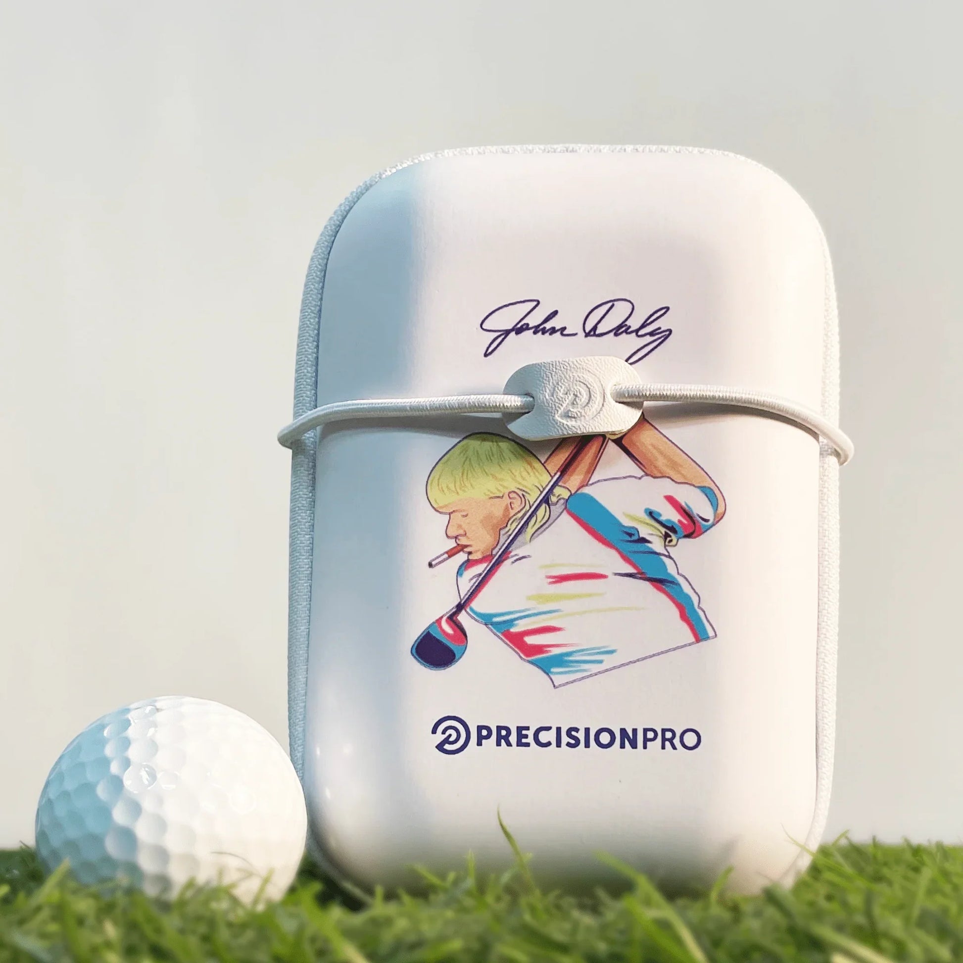 White hard shell golf rangefinder case with John Daly graphic and PrecisionPro logo beside golf ball on grass