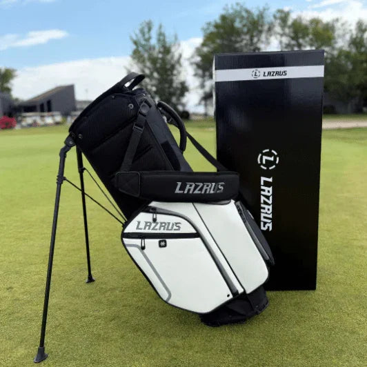 Lazrus branded black and white golf stand bag on green grass with Lazrus box in background under blue sky
