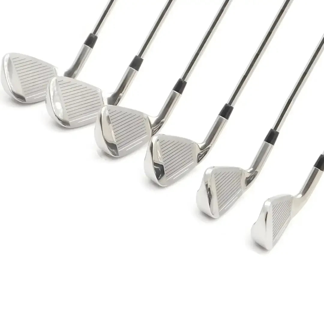 Set of polished silver golf irons arranged in a row isolated on white background