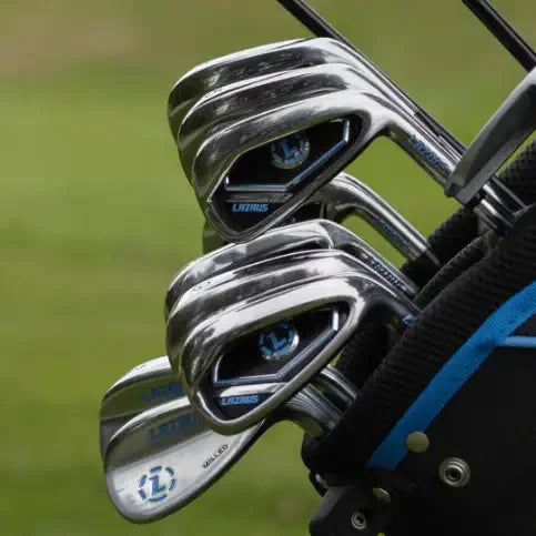 Set of Lazrus 2025 golf irons with chrome finish in a black and blue golf bag on grass