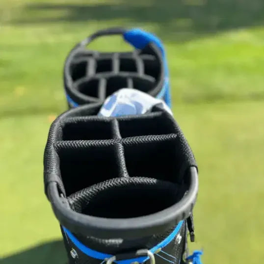 Black and blue premium golf bag with multiple compartments on a grassy golf course