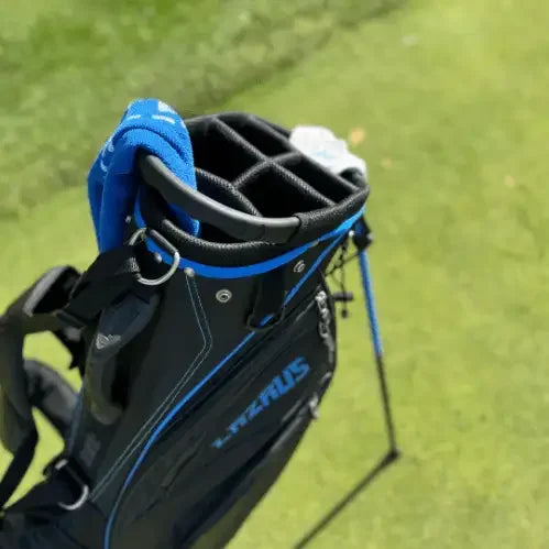 Premium black Lazrus golf bag with blue accents standing on grass with club dividers visible