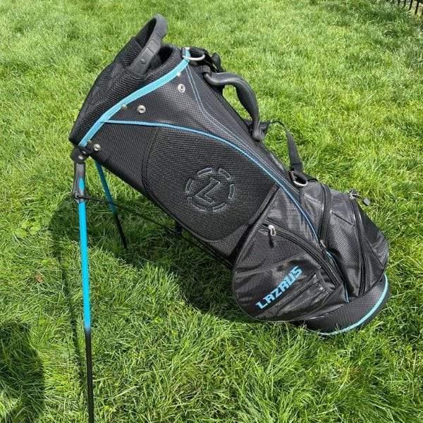 Black and blue Lazrus premium golf stand bag on green grass with multiple zippered pockets
