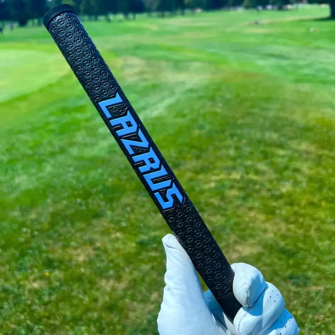 Close-up of black Lazrus golf club grip held by gloved hand on green golf course