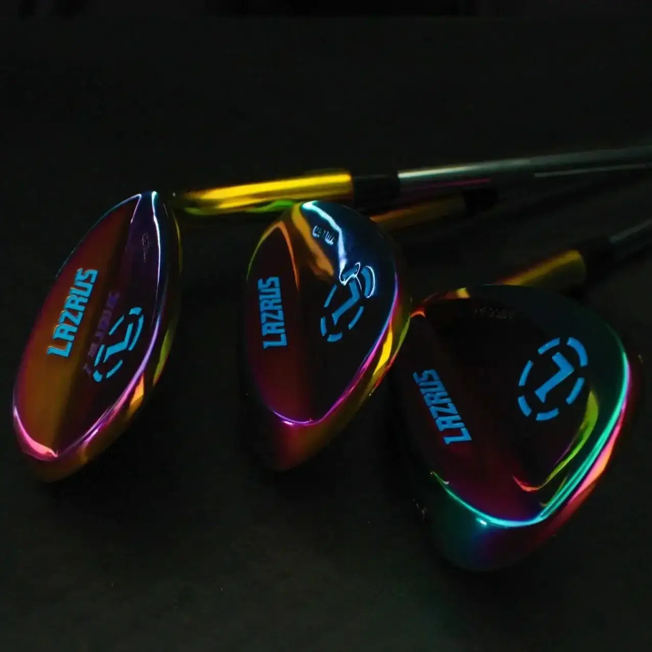 Set of three iridescent Lazrus forged golf wedges with colorful chrome finish on black background