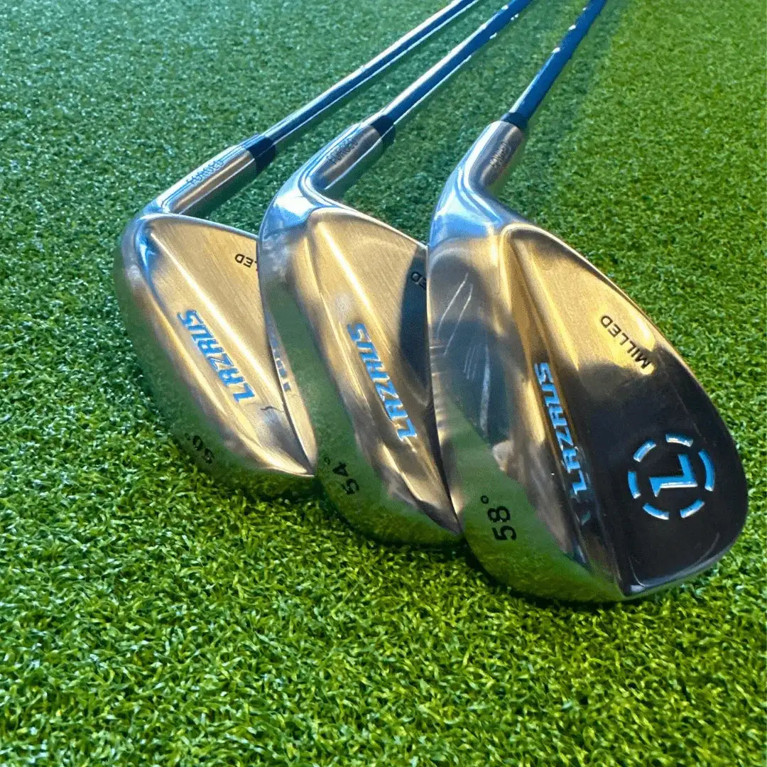 Set of three Lazrus forged golf wedges 50°, 54°, and 58° on green turf