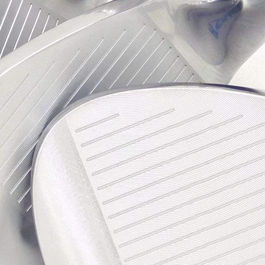 Close-up of forged golf wedges with grooved clubfaces in silver finish