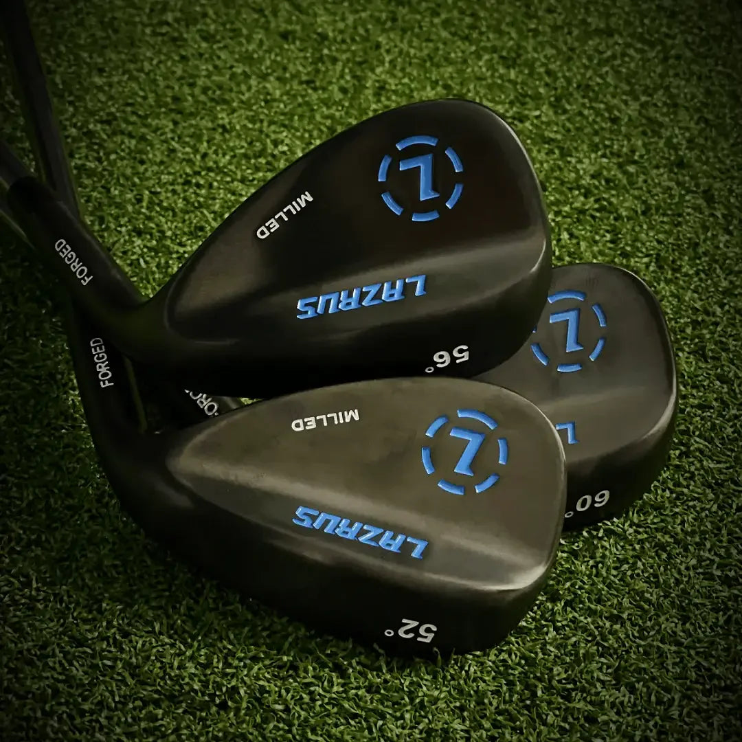 Set of three black Lazrus forged golf wedges with blue branding on green turf