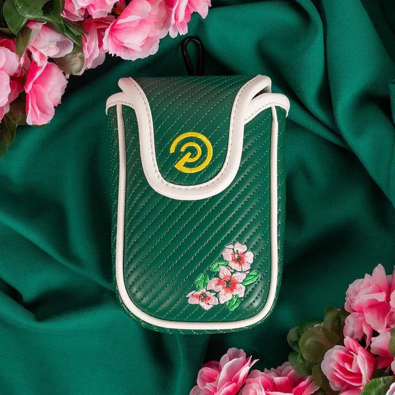 Green quilted soft shell rangefinder case with white trim and pink floral embroidery surrounded by pink flowers