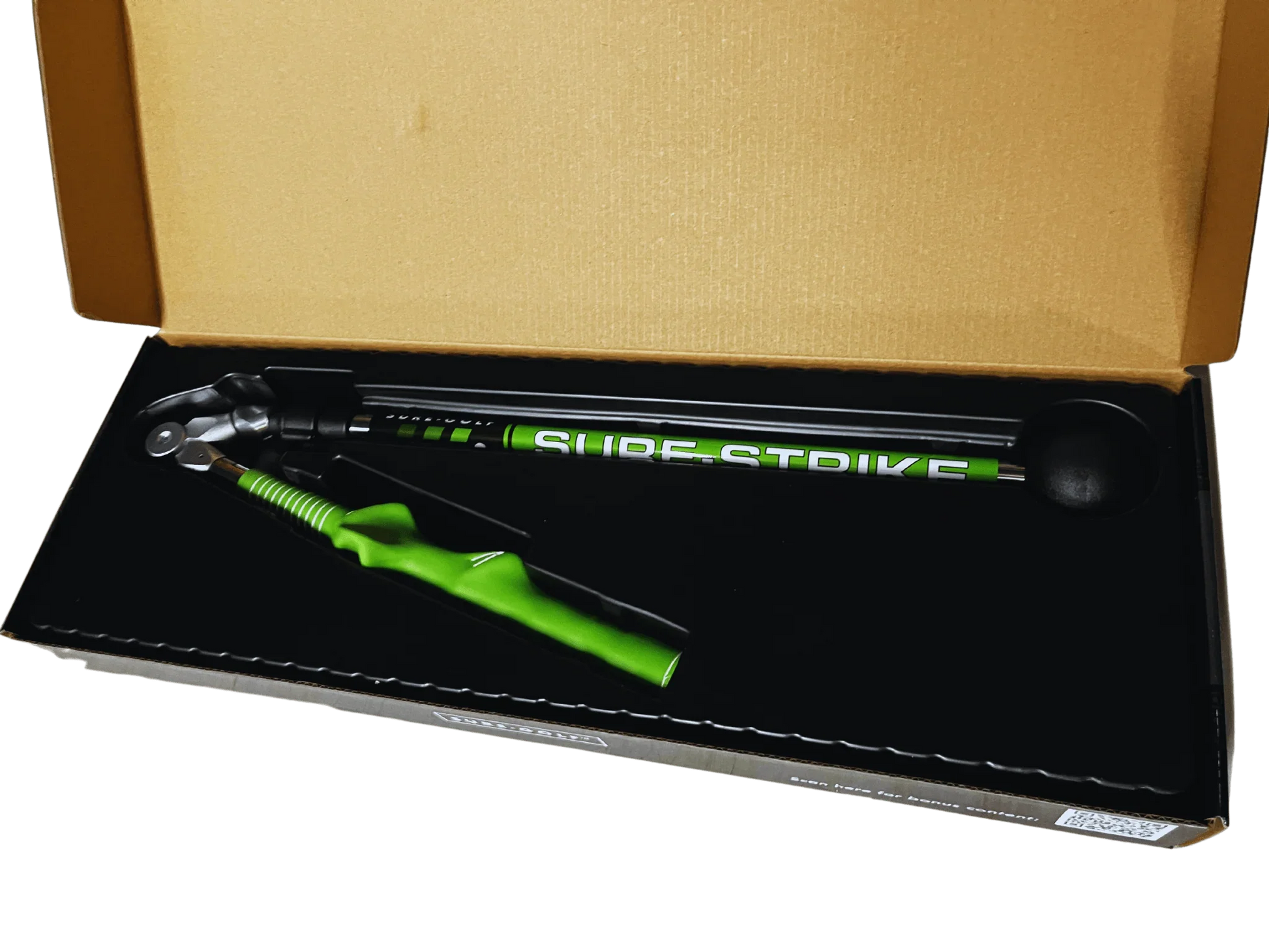 Sure Strike golf swing training aid with green handle in open box packaging