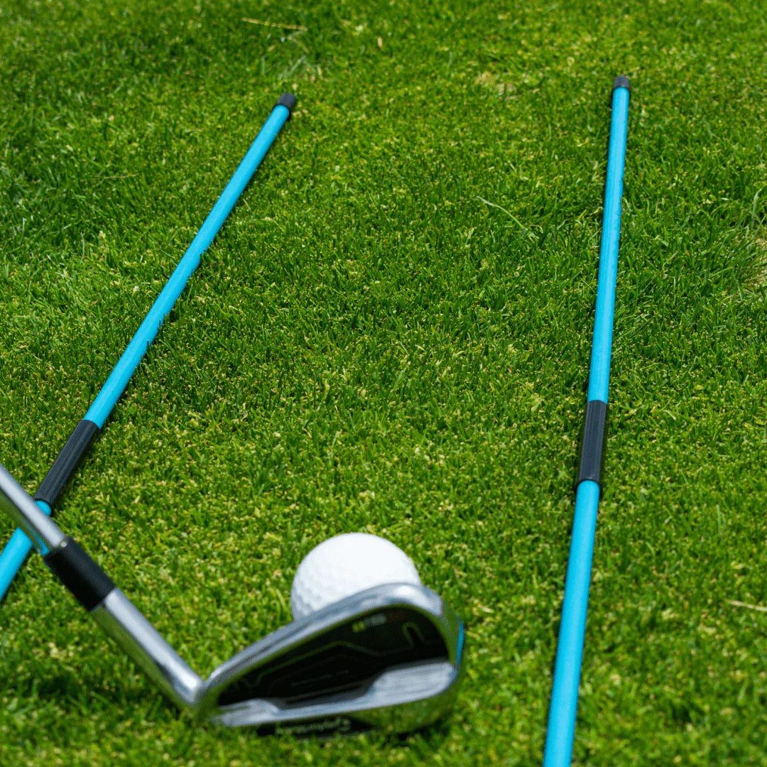 Golf alignment training sticks on green grass with golf club and ball for practice