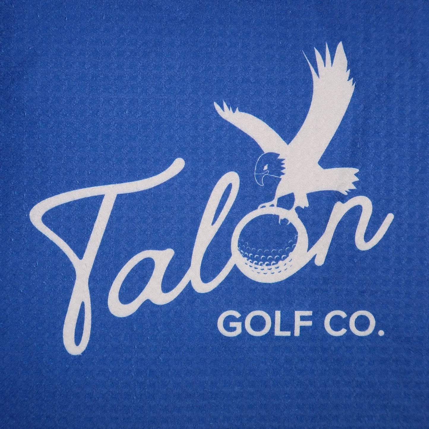 Blue golf towel with white Talon Golf Co. logo featuring an eagle clutching a golf ball