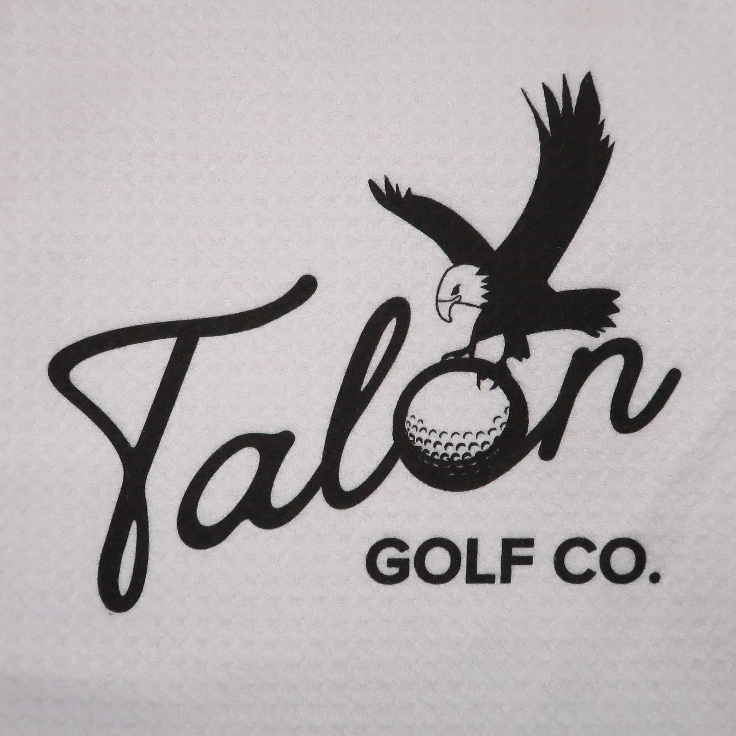Talon Golf Co. logo with eagle clutching a golf ball on textured white fabric