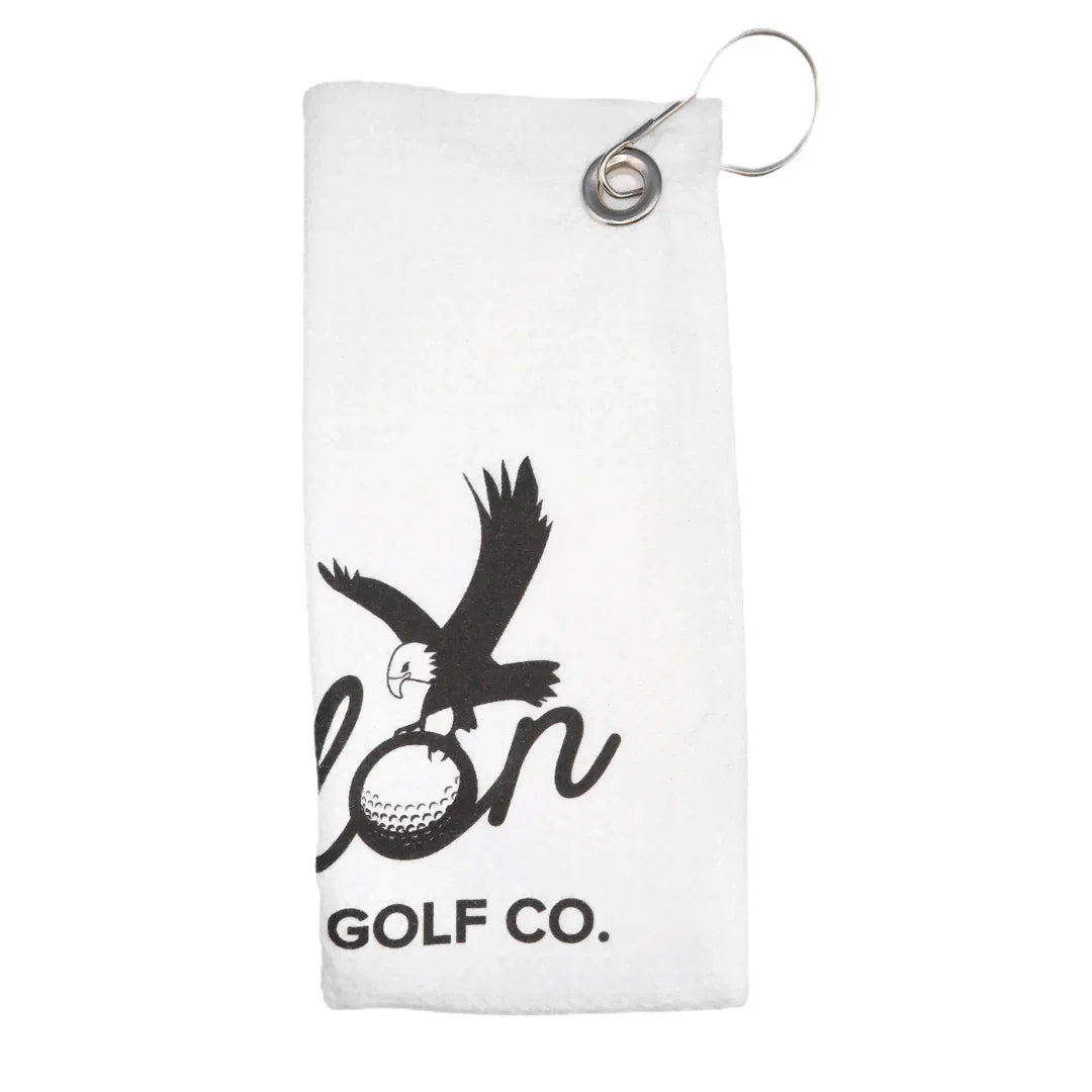 White golf towel with black eagle holding golf ball and text Talon Golf Co.