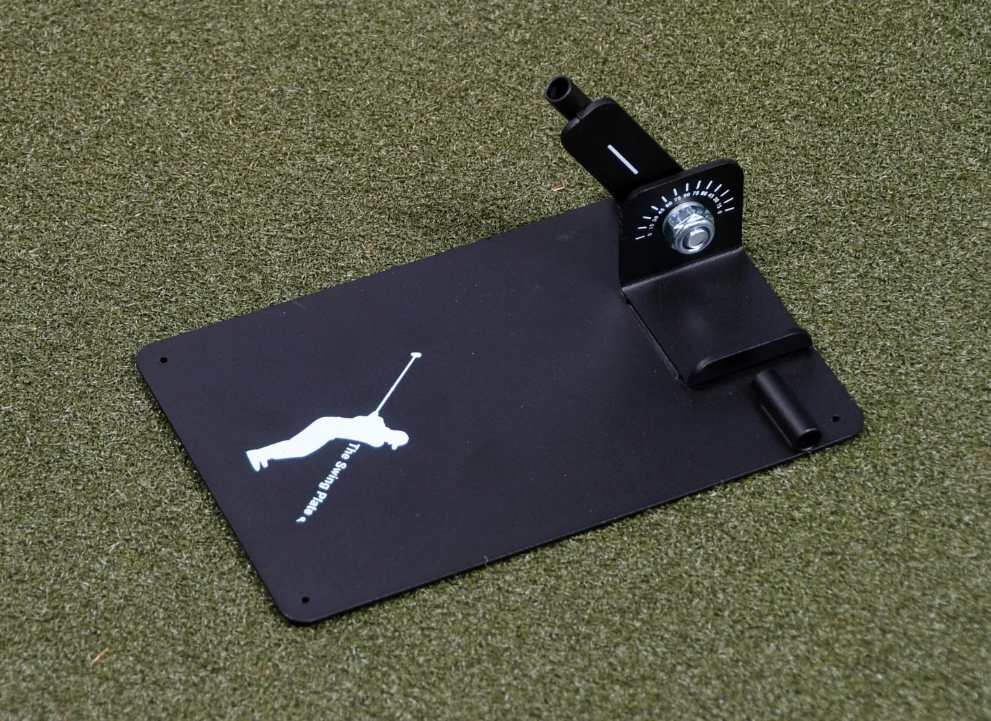 Black golf swing plate base with angle adjustment dial on artificial grass