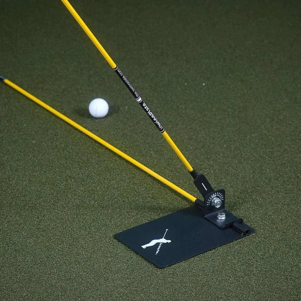 Swing plate golf training aid with yellow rods and white golf ball on green practice mat