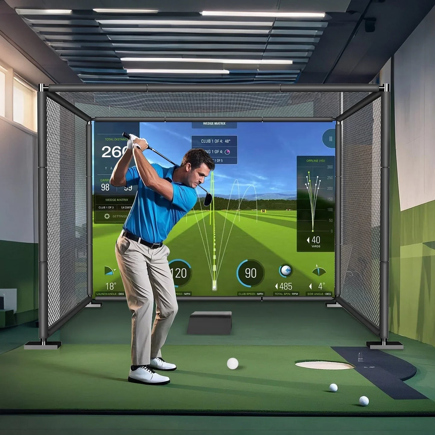 Man in blue shirt playing golf in indoor golf simulator cage with impact screen and metal frame
